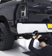 Homem instalando um acessório para pick-up preta para uso com carretinha reboque
