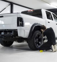 Técnico instalando engate de reboque em picape na oficina, seguindo boas práticas para instalar engates automotivos